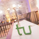A logo of TU Dortmund university is standing on a table. In the background there ist a chandelier. 