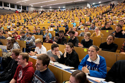 A full lecture hall with people listening and laughing.
