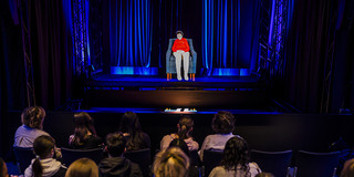 Foto aus dem Vorführraum, Schulklasse von hinten, die Hologramm von Zeitzeugin betrachtet