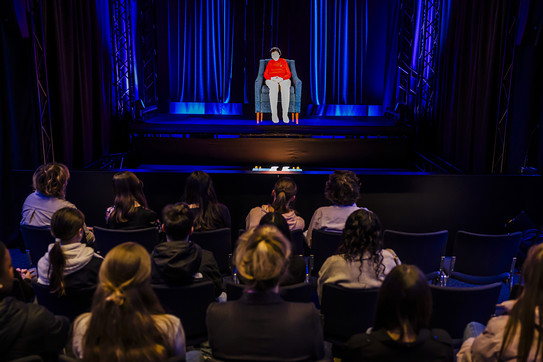 Foto aus dem Vorführraum, Schulklasse von hinten, die Hologramm von Zeitzeugin betrachtet