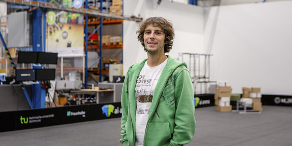 Portrait of a man standing in a large hall.