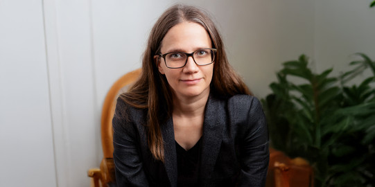 Porträtfoto von Prof. Eva Schmidt: Das Foto zeigt eine Frau mit Brille und langen dunklen Haaren.