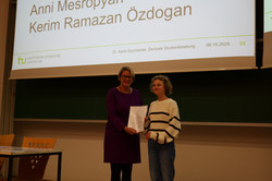 Eine junge Teilnehmerin der SchülerUni bekommt ein Zertifikat überreicht. 