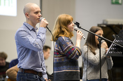 Drei Personen singen in Mikrofone.