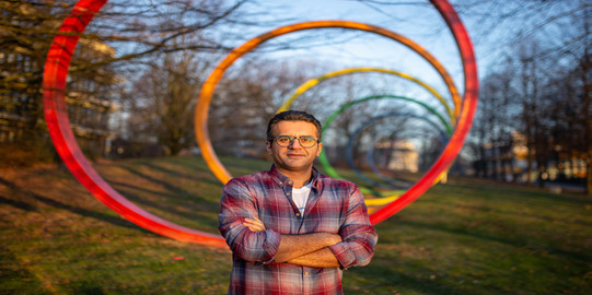 Vahid Farrahi Portrait eines Mannes vor den Spektralringen auf dem TU Campus
