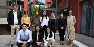Participants of the Ruhr Fellowship Program 2022 stand together with three women, including Prof. Tessa Flatten, in front of the International Meeting Center of TU Dortmund University.