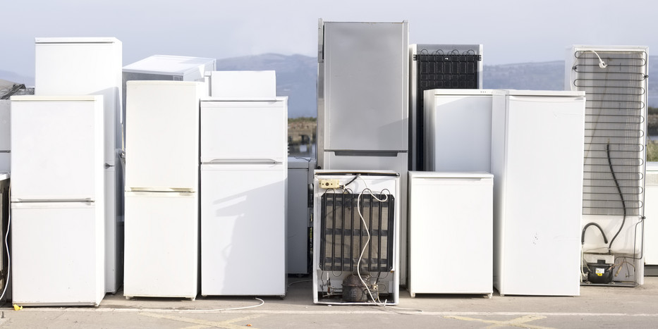 Several white refrigerators standing next to each other