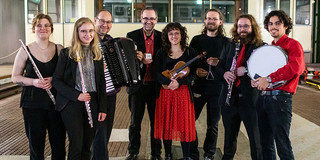 Ein Gruppenfoto des Ensemble für neue Kammermusik. Alle Musiker:innen halten ihre Instrumente im Arm.