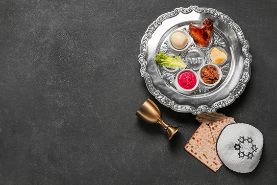 Auf dem Foto sieht man eine Kippa, einen Kelch und eine Schale mit Essen.