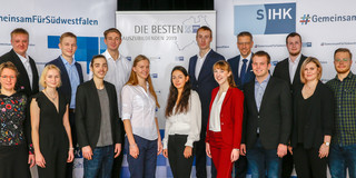 Group photo in front of a wall covered with the logo of the CCI