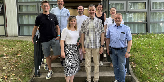 Gruppenfoto mit acht Personen vor einem Gebäude