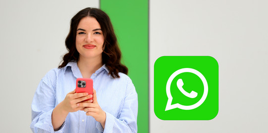 Studierende mit einem Mobiltelefon inkl. WhatsAPP-Logo