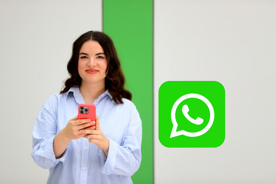 Studierende mit einem Mobiltelefon inkl. WhatsAPP-Logo