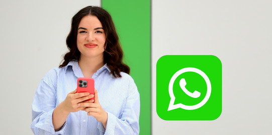 Studierende mit einem Mobiltelefon inkl. WhatsAPP-Logo