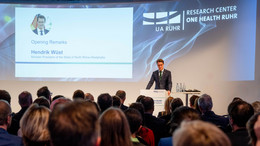 Foto: Ministerpräsident Hendrik Wüst steht an einem Redepult bei der Eröffnung des Research Centers One Health Ruhr. Vor ihm sitzen Menschen im Publikum.