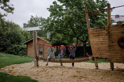 Three girls balancing on a rope.