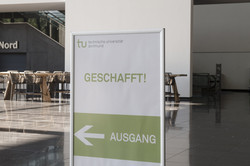 Information sign with directional indication A sign indicating the direction in which one should leave the examination room after the exam has been written.