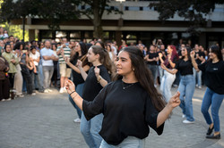 Auf dem Platz vor der Emil-Figge-Straße 50 zeigen Studentinnen einen anatolischen Volkstanz. Im Hintergrund ist das Publikum zu sehen.