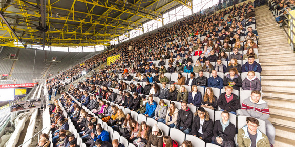 Junge Menschen sitzen auf den Rängen im Signal-Iduna-Park