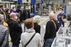 Several people are standing in a circle in a production hall.