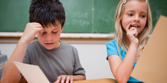 Schüler Lernsituation Ein Junge und ein Mädchen gucken auf Arbeitsblätter