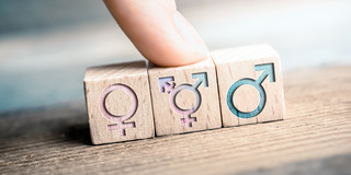 Weibliche, transgender und männliche Icons Weibliche, transgender und männliche Icons sind auf 3 Würfeln abgebildet, ein Finger zeigt auf das LGBT-Zeichen.