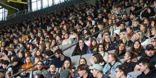 Eine Tribüne in einem Fußballstadion ist gefüllt mit Erstsemesterstudierenden.