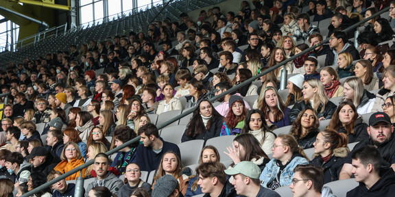 A grandstand in a soccer stadium is filled with first-year students.