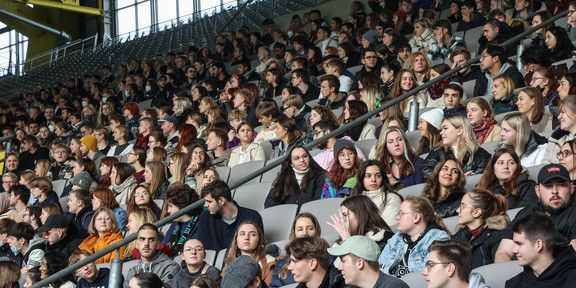 Eine Tribüne in einem Fußballstadion ist gefüllt mit Erstsemesterstudierenden.