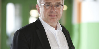 Prof. Roland Winter Porträtaufnahme in grün gestrichenem Flur