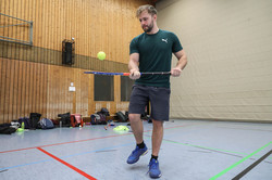 Ein Student balanciert einen Ball auf einem Hockeyschläger