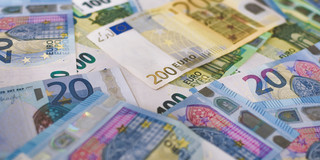 Inflation 20, 100 und 200-Euro-Scheine liegen kreuz und quer auf einem Tisch.