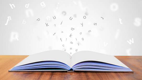 Arbeiten mit Literatur Geöffnetes Buch mit herausfliegenden Buchstaben.