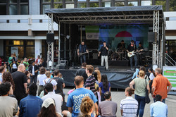 Foto: Vor dem Gebäude EF50 spielt eine Band auf einer großen Bühne.