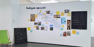 Route Mittelalter Ruhr_Ausstellung Eine Karte, Fotos und bunte Zettel mit Informationen hängen an einer Wand