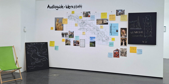 Route Mittelalter Ruhr_Ausstellung Eine Karte, Fotos und bunte Zettel mit Informationen hängen an einer Wand