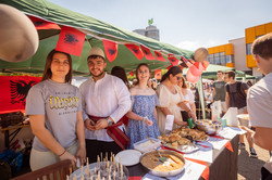 Internationale Studierende präsentieren an einem Stand traditionelle Speisen.