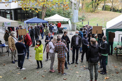 Several people are standing outside in front of a TU Dortmund building.