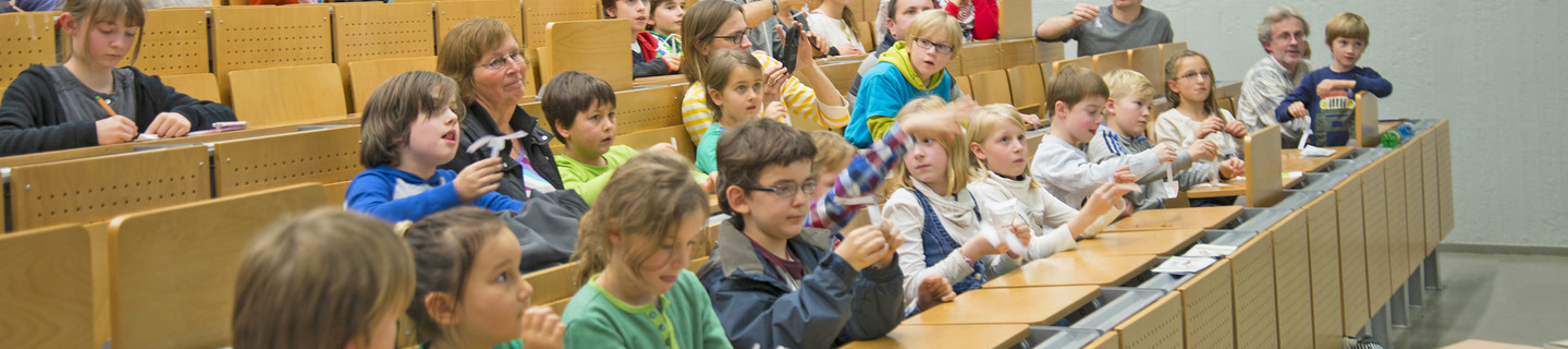 Kinder sitzen im Hörsaal