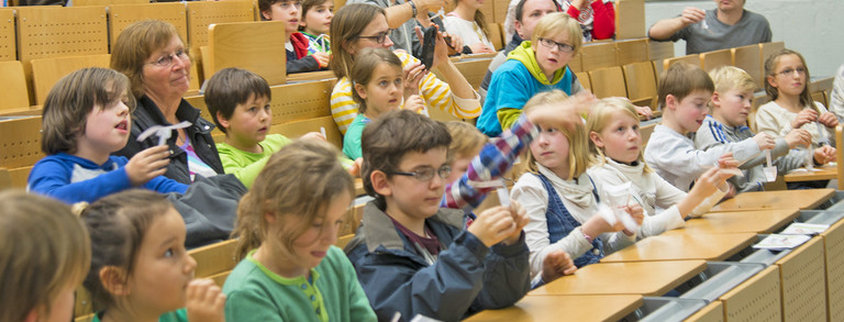 Kinder sitzen im Hörsaal