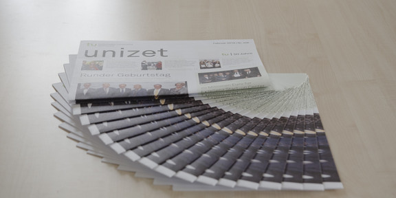 unizet 458 Mehrere Ausgaben der unizet liegen ausgefächert auf einem Tisch