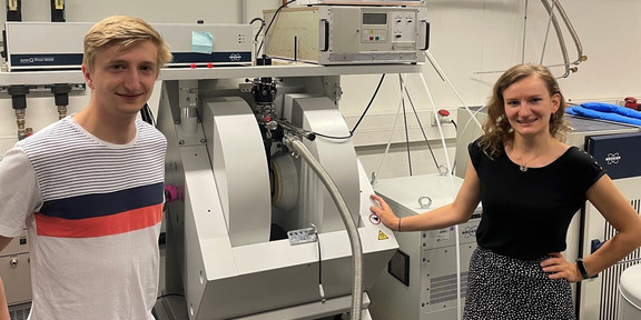 Electron Paramagnetic Resonance Spectroscopy A man and a woman stand next to an electron paramagnetic resonance spectrometer in a laboratory.