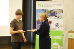 42_SchuelerUni_7794 Feierliche Übergabe erworbener Zertifikate zwischen der Prorektorin Studium Frau Prof. Dr. Wiebke Möhring und einem Teilnehmer während der Eröffnungsveranstaltung der SchülerUni für das Wintersemester 2024/2025.