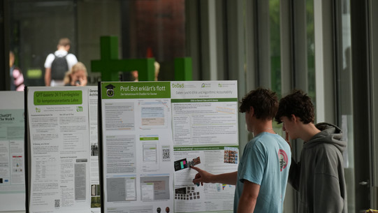 20260706_Lernen_Lehren und Prüfen mit KI_BenediktTobiasMüller_234 Besucher*innen stehen vor einem Poster in der Poster-Galerie.