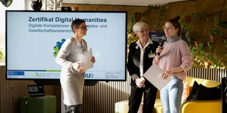 Foto: Dr. Stephanie Heimgartner und Prof. Kornelia Freitag von der Ruhr-Universität Bochum überreichen einer Studentin ihr Digital-Humanities-Zertifikat.