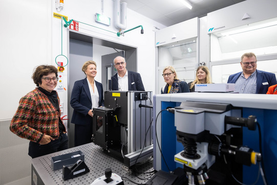 Mehrere Personen stehen in einem Labor um einen Tisch, auf dem verschiedene Geräte stehen