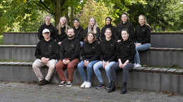 Ein Gruppenfoto von 12 Personen in gleichen Pullover
