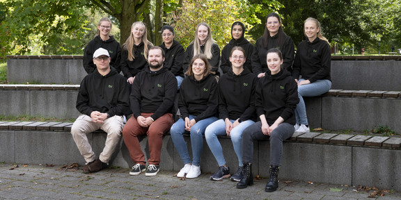 Ein Gruppenfoto von 12 Personen in gleichen Pullover