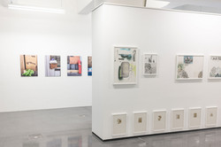 Ausstellung „Laufende Beobachtungen“ In einer Ausstellung hängen Bilder an einer weißen Wand.