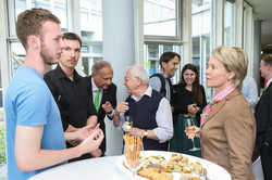 Frances Arnold steht an einem Stehtisch auf dem Kanapees stehen und unterhält sich mit zwei Studenten.